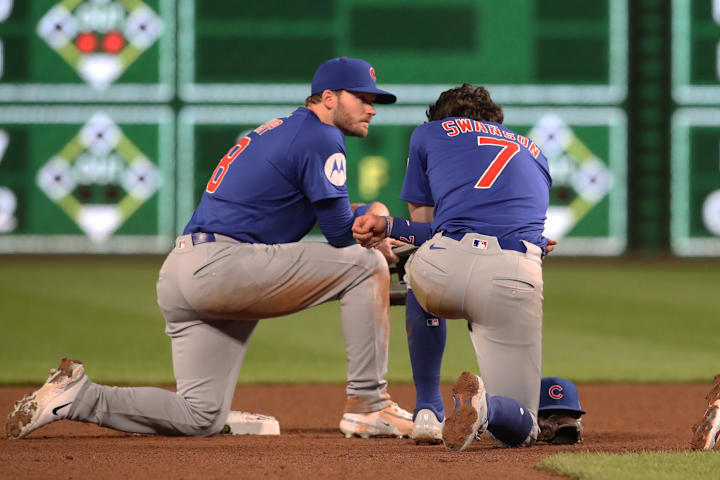Chicago Cubs players are visibly shaken as Pittsburgh Pirates medical personnel treat a fan who fell from the stands.