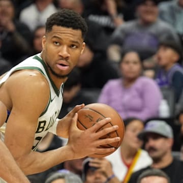 Mar 22, 2025; Sacramento, California, USA; Milwaukee Bucks forward Giannis Antetokounmpo (center) handles the ball against Sacramento Kings forward Keegan Murray (13) during the second quarter at Golden 1 Center. Mandatory Credit: Darren Yamashita-Imagn Images