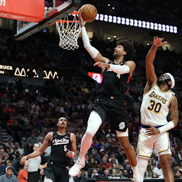 Apr 13, 2025; Portland, Oregon, USA; Portland Trail Blazers guard Matisse Thybulle (4) shoots the ball over Los Angeles Lakers guard Jordan Goodwin (30) as Trail Blazers’ guard Dalano Banton (5) watches in the first half at Moda Center. Mandatory Credit: Jaime Valdez-Imagn Images
