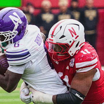 Oct 25, 2025; Lincoln, Nebraska, USA; Northwestern Wildcats running back Joseph Himon II (6) runs with the ball against Nebraska Cornhuskers defensive lineman Cameron Lenhardt (11) during the fourth quarter at Memorial Stadium. Mandatory Credit: Dylan Widger-Imagn Images