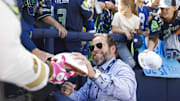 Oct 6, 2024; Seattle, Washington, USA; Seattle Seahawks general manager John Schneider signs sutographs during pregame warmups against the New York Giants at Lumen Field.