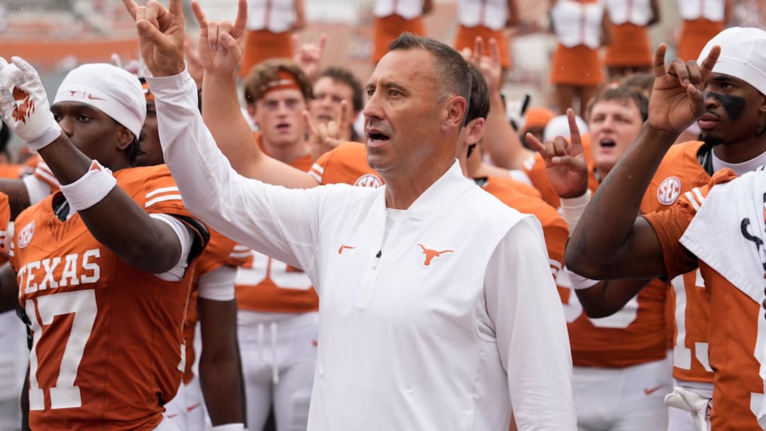 Texas Longhorns head coach Steve Sarkisian and players hold up their horns with the fans during the singing of the Eyes of Texas after a victory over the San Jose State Spartans at Darrell K Royal-Texas Memorial Stadium.