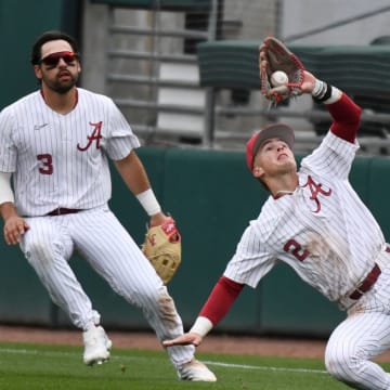 Feb 17, 2024; Tuscaloosa, Alabama, USA; Alabama second baseman Mason Swinney makes a difficult catch on a fly ball behind first base with right fielder Evan Sleight backing him up during the game with Manhattan at Sewell-Thomas Stadium Saturday.