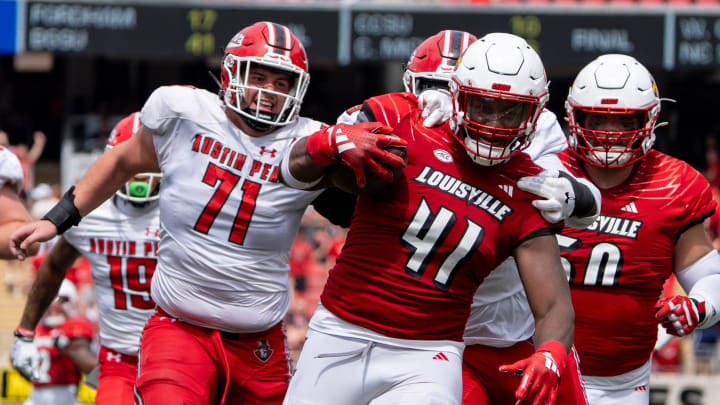 Louisville Cardinals defensive lineman Ramon Puryear (41) runs to the end zone for a touchdown through the Austin Peay Governors defensive line during their game on Saturday, Aug. 31, 2024 at L&N Federal Credit Union Stadium in Louisville, Ky.