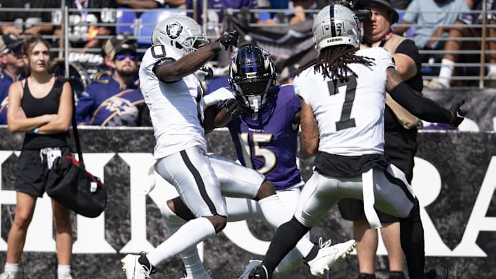 Sep 15, 2024; Baltimore, Maryland, USA;  h15] can’t secure a a pass as Las Vegas Raiders cornerback Jakorian Bennett (0) and  safety Tre'von Moehrig (7) defend during the first half at M&T Bank Stadium. Mandatory Credit: Tommy Gilligan-Imagn Images