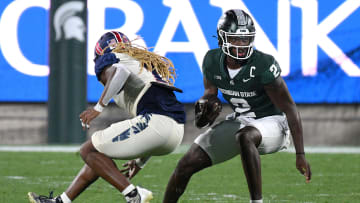 Aug 30, 2024; East Lansing, Michigan, USA;  Michigan State Spartans quarterback Aidan Chiles (2) evades Florida Atlantic Owls safety CJ Heard (1) in the third quarter at Spartan Stadium. Mandatory Credit: Dale Young-USA TODAY Sports