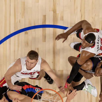 Mar 15, 2024; Detroit, Michigan, USA; Detroit Pistons forward Tosan Evbuomwan (18) drives to the basket in front of Miami Heat forward Nikola Jovic (5) as Pistons center Jalen Duren (0) defends against the Heat’s center Bam Adebayo (13) during the in the first half at Little Caesars Arena. Mandatory Credit: David Reginek-USA TODAY Sports