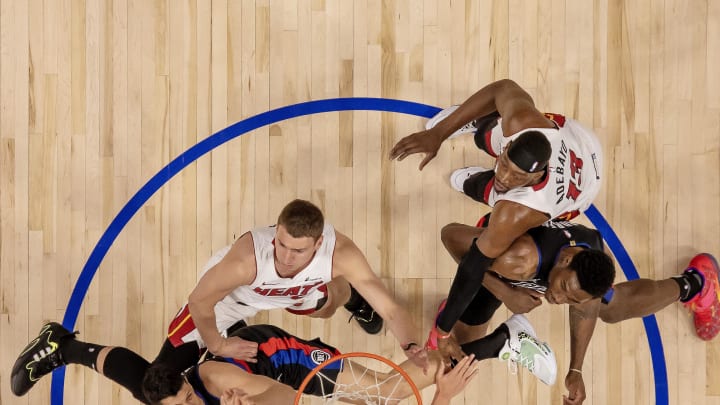 Mar 15, 2024; Detroit, Michigan, USA; Detroit Pistons forward Tosan Evbuomwan (18) drives to the basket in front of Miami Heat forward Nikola Jovic (5) as Pistons center Jalen Duren (0) defends against the Heat’s center Bam Adebayo (13) during the in the first half at Little Caesars Arena. Mandatory Credit: David Reginek-USA TODAY Sports