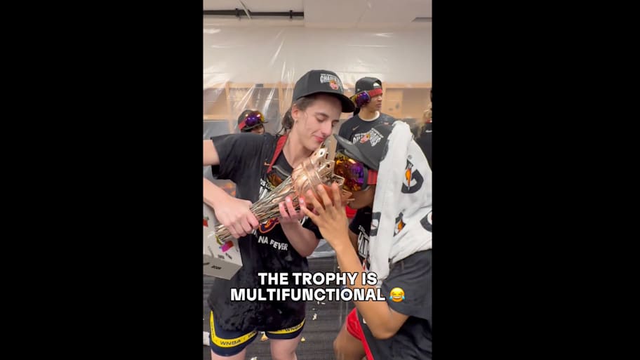 Clark holds the WNBA Commissioner's Cup trophy in the locker room following the Fever's win over the Lynx | Screengrab via @WNBA on X/Twitter