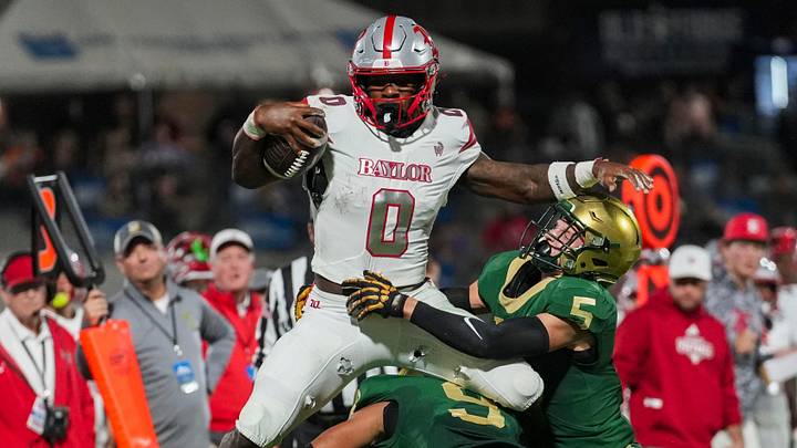 Baylor's David Gabriel-Georges (0) leaps over Knoxville Catholic's Julian Sensabaugh (9) and Knoxville Catholic's Brooks Johnston (5) during a high school football game between Baylor and Knoxville Catholic at Covenant Heath Park in Knoxville, Tenn., on Oct. 30, 2026.