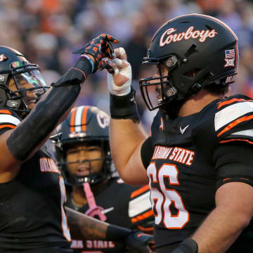 Oct 6, 2023; Stillwater, Oklahoma, USA; Oklahoma State player Ollie Gordon II (0) celebrates his touchdown with Oklahoma State's Joe Michalski (66) in the first half of the college football game between the Oklahoma State University Cowboys and the Kansas State Wildcats at Boone Pickens Stadium. Mandatory Credit: Sarah Phipps-USA TODAY Sports