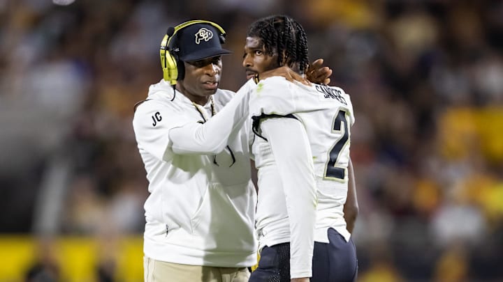 Colorado head coach Deion Sanders speaking to son and Buffaloes quarterback Shedeur Sanders after a penalty during a game in October of 2023. 