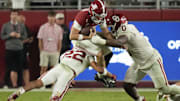 Oklahoma defensive tackle David Stone (0) and safety Peyton Bowen (22) hit Alabama quarterback Ty Simpson.