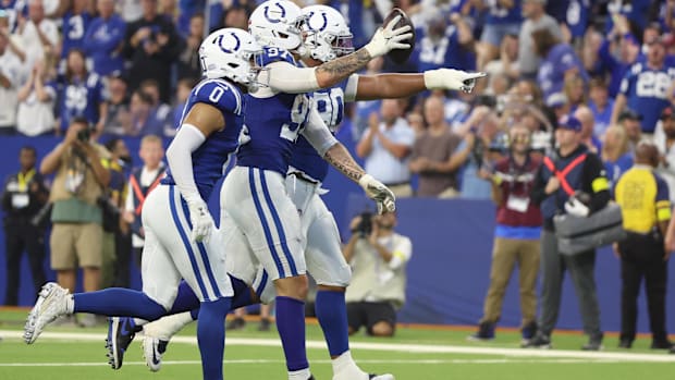 Colts defensive end Laiatu Latu (blue and white uniform) runs off the field.