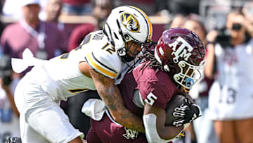 Oct 5, 2024; College Station, Texas, USA; Missouri Tigers cornerback Dreyden Norwood (12) tackles Texas A&M Aggies running back Amari Daniels (5) runs the ball in the first quarter at Kyle Field. Mandatory Credit: Maria Lysaker-Imagn Images. 