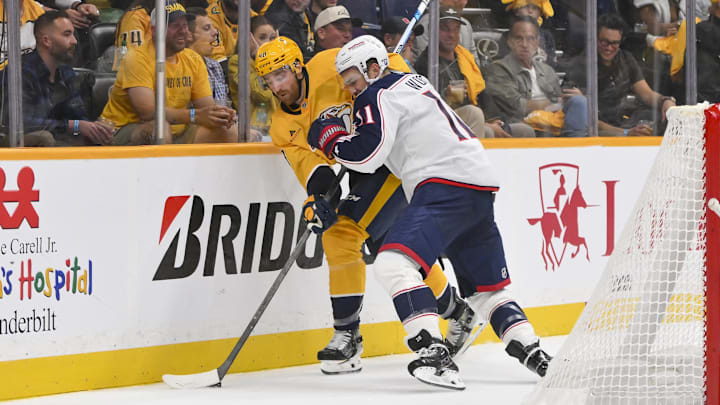 Blue Jackets forward Miles Wood lays a hit on Predators defenseman Nick Perbix. 