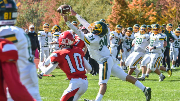 Burr and Burton's Jack McCoy tries to tip the ball out of CVU's Dylan Frere's reach during the Bulldogs' game vs the Redhawks