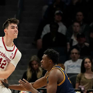 Mar 12, 2025; Charlotte, NC, USA; Stanford Cardinal forward Maxime Raynaud (42) passes the ball as California Golden Bears center Mady Sissoko (12) defends in the second half at Spectrum Center. Mandatory Credit: Bob Donnan-Imagn Images