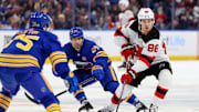 Mar 29, 2024; Buffalo, New York, USA;  New Jersey Devils center Jack Hughes (86) carries the puck up ice as Buffalo Sabres center Dylan Cozens (24) defends during the first period at KeyBank Center. Mandatory Credit: Timothy T. Ludwig-Imagn Images