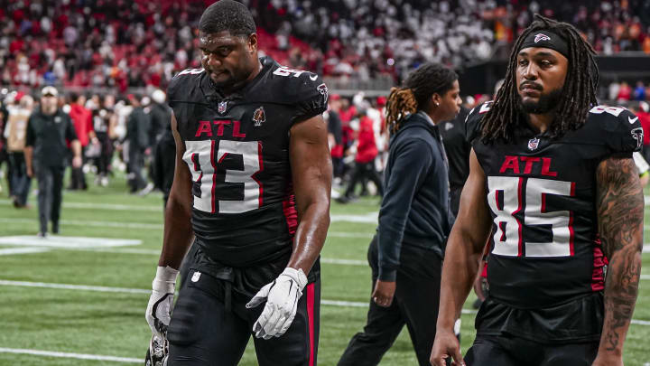 New Miami Dolphins defensive tackle Calais Campbell (93) and tight end MyCole Pruitt (85) leave the field after an Atlanta Falcons loss against the Tampa Bay Buccaneers at Mercedes-Benz Stadium in 2023.