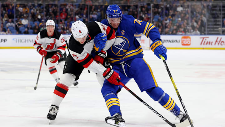 New Jersey Devils defenseman John Marino and Buffalo Sabres right wing Tage Thompson battle for a loose puck during the second period.