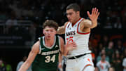 Nov 3, 2025; Coral Gables, Florida, USA; Jacksonville Dolphins guard Evan Sterck (34) drives to the basket against Miami Hurricanes guard Dante Allen (35) during the second half at Watsco Center. Mandatory Credit: Sam Navarro-Imagn Images