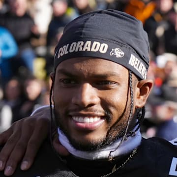 Nov 29, 2024; Boulder, Colorado, USA; Colorado Buffaloes safety Shilo Sanders (21) and head coach Deion Sanders and quarterback Shedeur Sanders (2) and social media producer Deion Sanders Jr. following the win against the Oklahoma State Cowboys at Folsom Field. Mandatory Credit: Ron Chenoy-Imagn Images