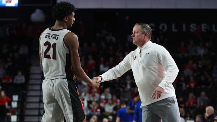 Dec 22, 2025; Athens, Georgia, USA; Georgia Bulldogs head coach Mike White talks to Georgia Bulldogs forward Jake Wilkins (21) against the West Georgia Wolves in the second half at Stegeman Coliseum. Mandatory Credit: Mady Mertens-Imagn Images