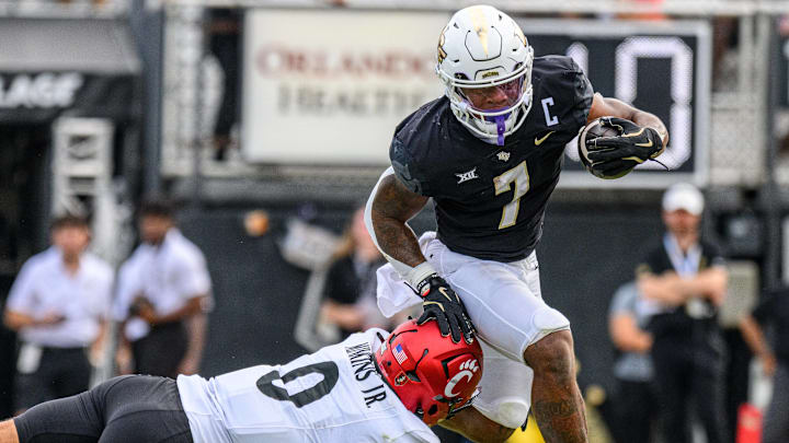 NCAA, College League, USA Football 2024: Cincinnati Bearcats vs Central Florida OCT 12 October 12, 2024: Cincinnati Bearcats defensive back Josh Minkins (0) attempts to tackle UCF Knights running back RJ Harvey (7) during NCAA football game between the Cincinnati Bearcats and the UCF Knights at FBC Mortgage Stadium in Orlando, FL. NCAA, College League, USA Football 2024: Cincinnati Bearcats vs Central Florida OCT 12 October 12, 2024: Cincinnati Bearcats defensive back Josh Minkins (0) attempts to tackle UCF Knights running back RJ Harvey (7) during NCAA football game between the Cincinnati Bearcats and the UCF Knights at FBC Mortgage Stadium in Orlando, FL.