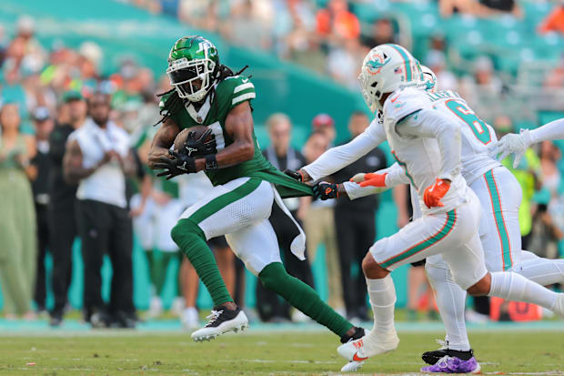 New York Jets wide receiver Davante Adams (17) runs with the football against the Miami Dolphins