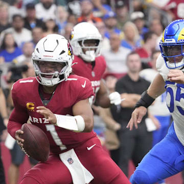 Arizona Cardinals quarterback Kyler Murray (1) spins away from Los Angeles Rams defensive tackle Braden Fiske (55) during the first quarter at State Farm Stadium.