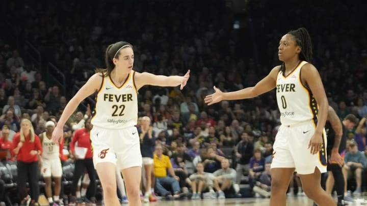 Jun 30, 2024; Phoenix, Ariz., U.S.; Indiana Fever guard Caitlin Clark (22) slaps hands with guard Kelsey Mitchell (0) during the third quarter against the Phoenix Mercury at Footprint Center. Mandatory Credit: Michael Chow-Arizona Republic