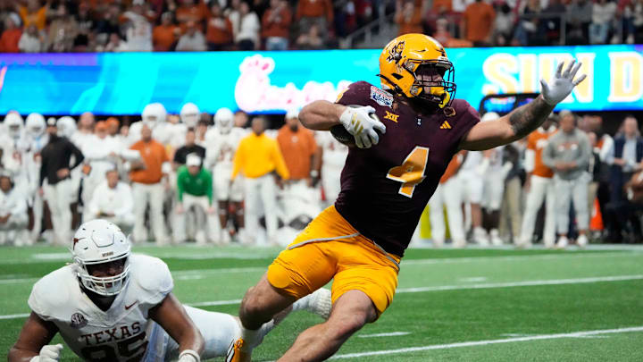Arizona State running back Cam Skattebo (4) escapes a tackle by Texas defensive lineman Alfred Collins (95) during the fourth quarter in the Chick-fil-A Peach Bowl in Atlanta on Wednesday, Jan. 1, 2025.