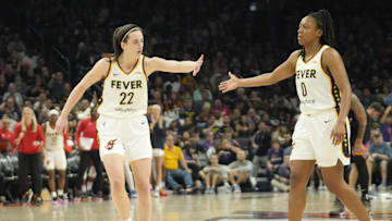 Jun 30, 2024; Phoenix, Ariz., U.S.; Indiana Fever guard Caitlin Clark (22) slaps hands with guard Kelsey Mitchell (0) during the third quarter against the Phoenix Mercury at Footprint Center. Mandatory Credit: Michael Chow-Arizona Republic