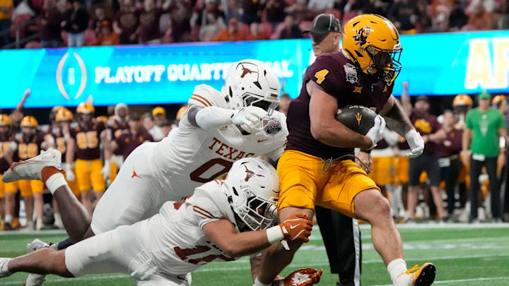 Arizona State running back Cam Skattebo (4) runs past Texas linebacker Anthony Hill Jr. (0) and Texas linebacker Liona Lefau (18) during the third quarter of the Chick-fil-A Peach Bowl in Atlanta on Wednesday, Jan. 1, 2025. Arizona State running back Cam Skattebo (4) runs past Texas linebacker Anthony Hill Jr. (0) and Texas linebacker Liona Lefau (18) during the third quarter of the Chick-fil-A Peach Bowl in Atlanta on Wednesday, Jan. 1, 2025.