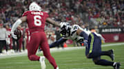 Arizona Cardinals running back James Conner (6) pushes away Seattle Seahawks linebacker Jordyn Brooks (56) during the third quarter at State Farm Stadium in Glendale on Jan. 7, 2024.