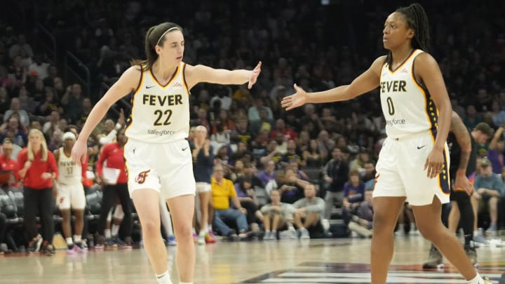 Indiana Fever guard Caitlin Clark (22) slaps hands with guard Kelsey Mitchell (0).