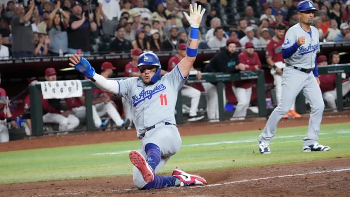 Los Angeles Dodgers’ Miguel Rojas (11) scores against the Arizona Diamondbacks during the eighth inning.