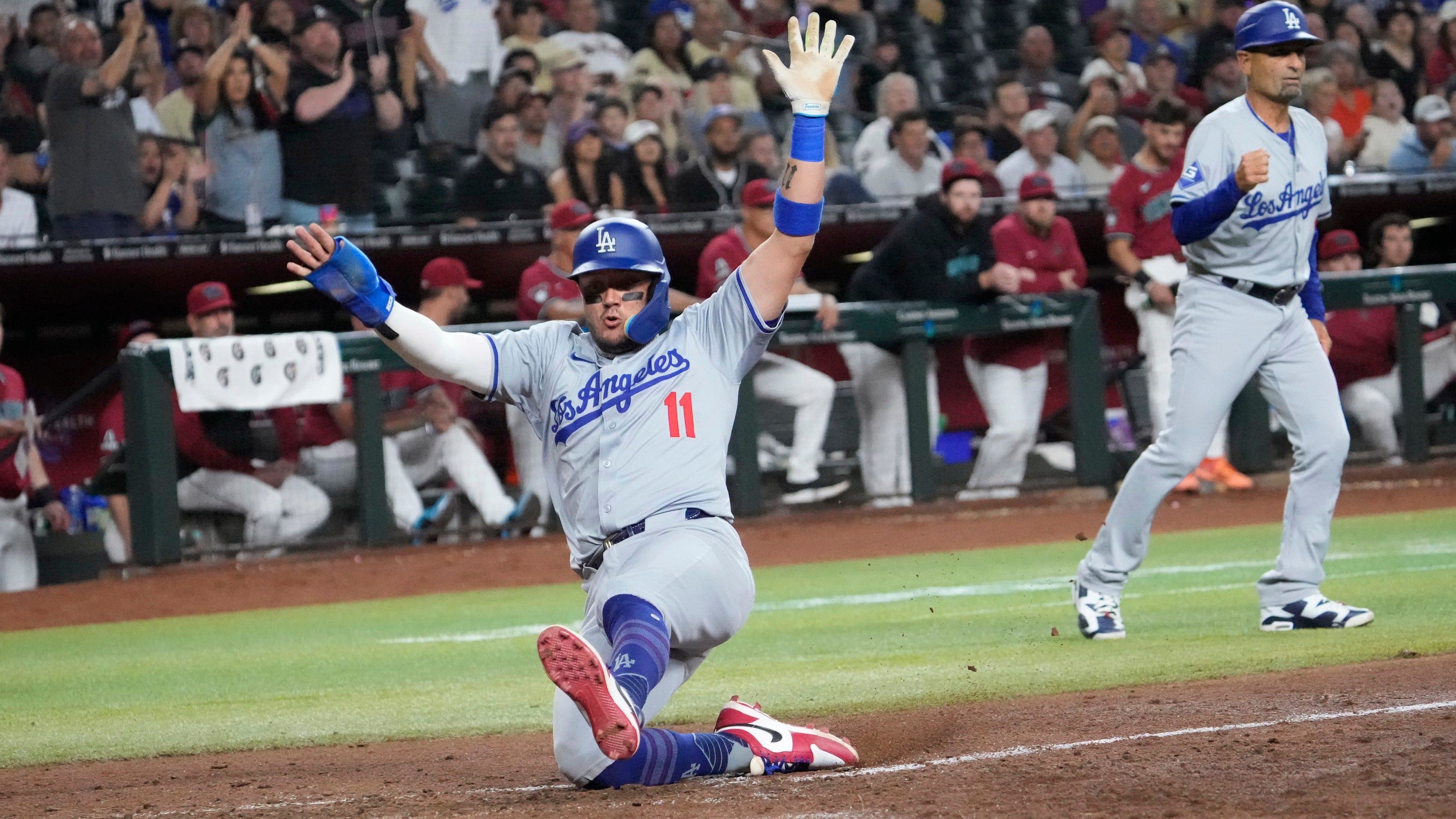 Los Angeles Dodgers’ Miguel Rojas (11) scores against the Arizona Diamondbacks during the eighth inning.