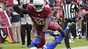 Arizona Cardinals wide receiver Marvin Harrison Jr. (18) reaches the ball for a touchdown against Los Angeles Rams safety Kamren Curl (3) during the first quarter at State Farm Stadium.