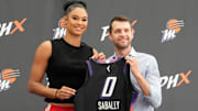 Mercury forward Satou Sabally holds her jersey with general manager Nick U’Ren during a news conference.