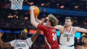 Alabama forward Sam Walters (24) is defended by Connecticut guard Hassan Diarra (10) and forward Alex Karaban (11) during the Final Four semifinal game at State Farm Stadium.