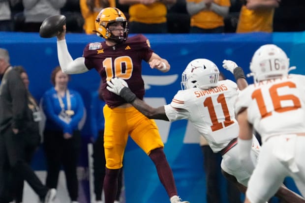 Sam Leavitt throws under pressure by Texas linebacker Colin Simmons.