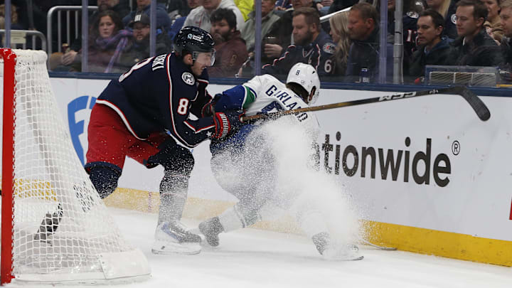 Blue Jackets defenseman Zach Werenski checks Canucks forward Conor Garland-who was traded to the Blue Jackets late Thursday night.