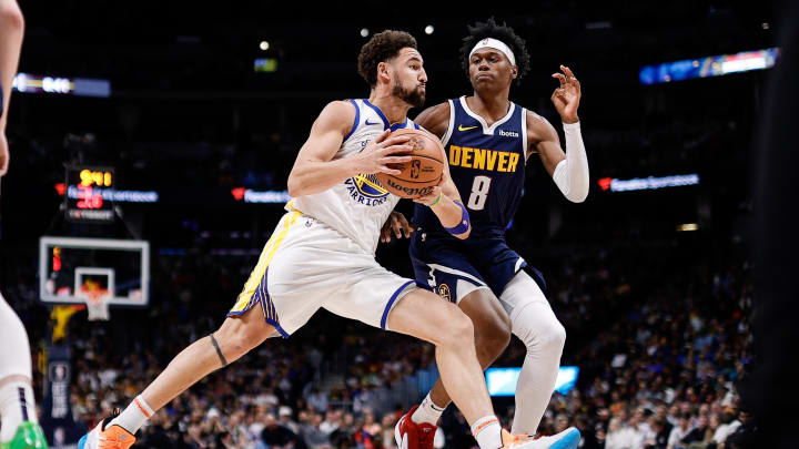 Nov 8, 2023; Denver, Colorado, USA; Golden State Warriors guard Klay Thompson (11) controls the ball against Denver Nuggets forward Peyton Watson (8) in the second quarter at Ball Arena. Mandatory Credit: Isaiah J. Downing-USA TODAY Sports