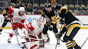 Oct 1, 2024; Pittsburgh, Pennsylvania, USA;  Detroit Red Wings goaltender Ville Husso (35) defends the net against Pittsburgh Penguins left wing Michael Bunting (8) and right wing Bryan Rust (right) during the third period at PPG Paints Arena. Detroit won 2-1. Mandatory Credit: Charles LeClaire-Imagn Images