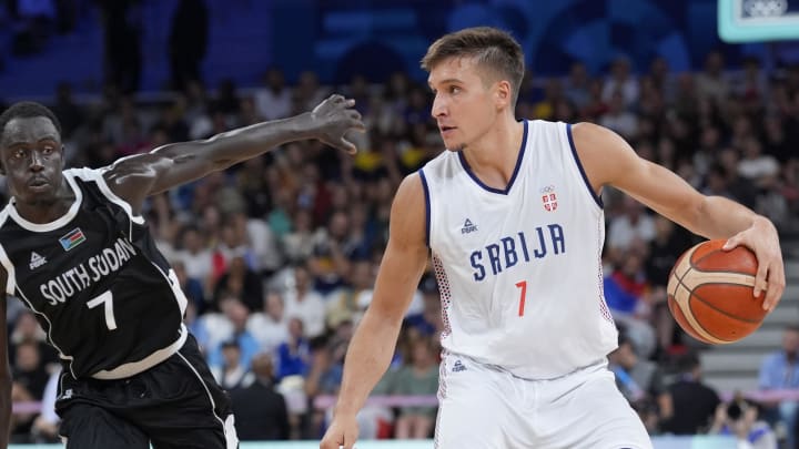 Aug 3, 2024; Villeneuve-d'Ascq, France; Serbia shooting guard Bogdan Bogdanovic (7) dribbles against South Sudan shooting guard Bul Kuol (7) in the fourth quarter during the Paris 2024 Olympic Summer Games at Stade Pierre-Mauroy. Mandatory Credit: John David Mercer-USA TODAY Sports