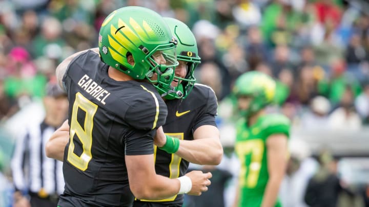 Oregon quarterback Dillon Gabriel congratulates Luke Moga after a touchdown.