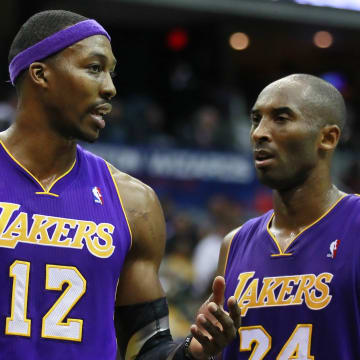 December 14, 2012; Washington, DC, USA;  Los Angeles Lakers shooting guard Kobe Bryant (24) and Lakers center Dwight Howard (12) talk on the court against the Washington Wizards in the fourth quarter at Verizon Center. The Lakers won 102-96. Mandatory Credit: Geoff Burke-USA TODAY Sports