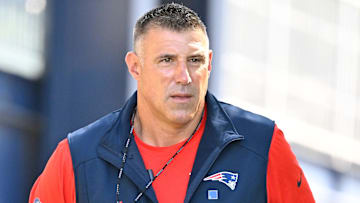 Jul 23, 2025; Foxborough, MA, USA; New England Patriots head coach Mike Vrabel delivers a puppy to a local family as part of the Patriots pet adoption event before the start of training camp at Gillette Stadium. Mandatory Credit: Eric Canha-Imagn Images